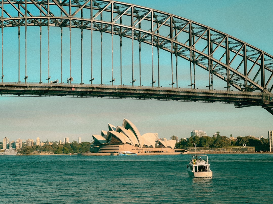 A boat in a body of water under a bridge